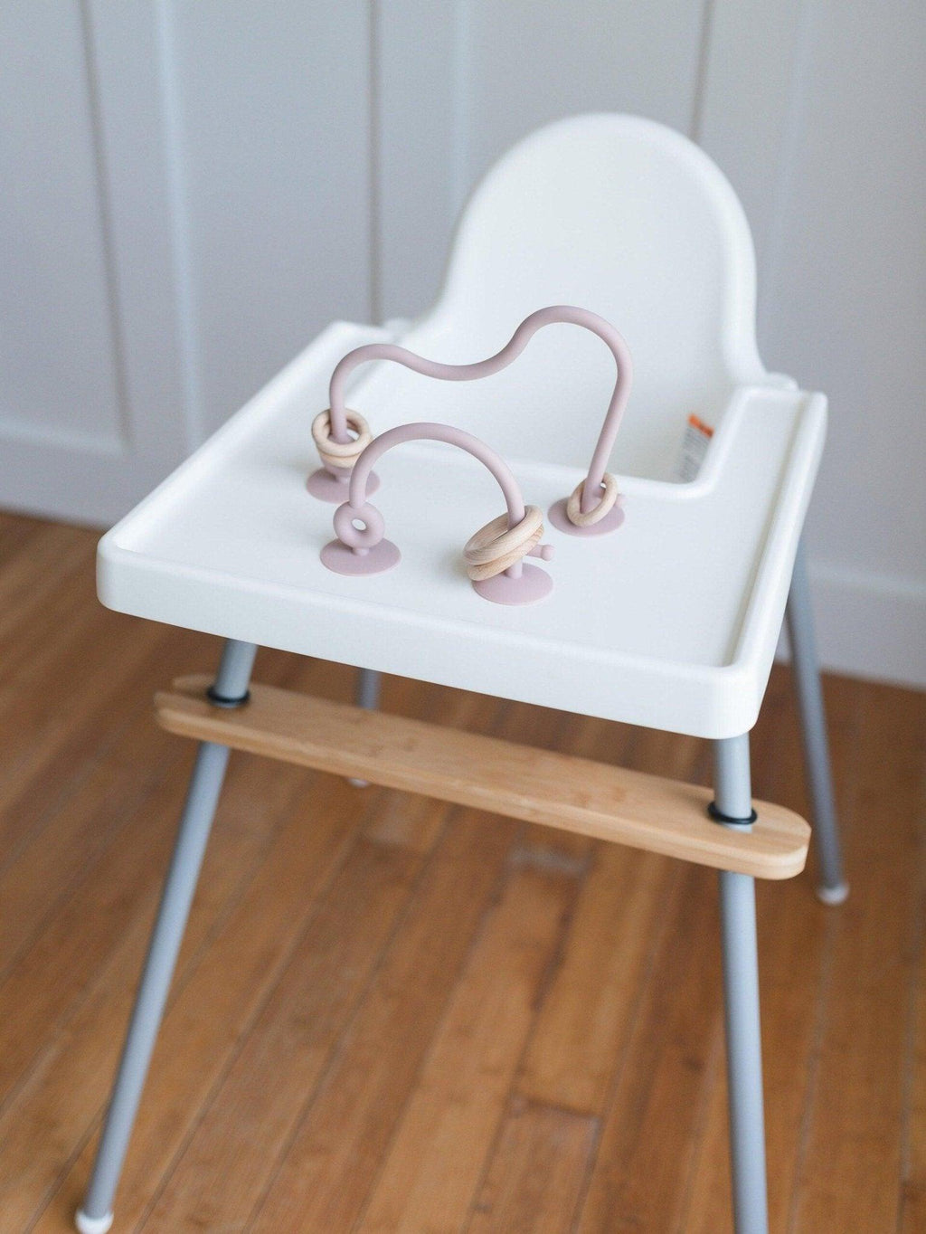 Silicone highchair toy set with pink arches and two hanging ring toys on tray