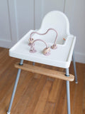 Silicone highchair toy set with pink arches and two hanging ring toys on tray