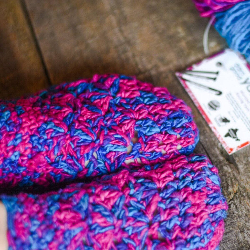 Close-up of crocheted slipper with pink and blue textured stitch upper