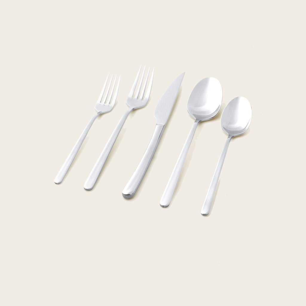 Silver mirror-finish flatware set, assorted forks, knives, and spoons on display