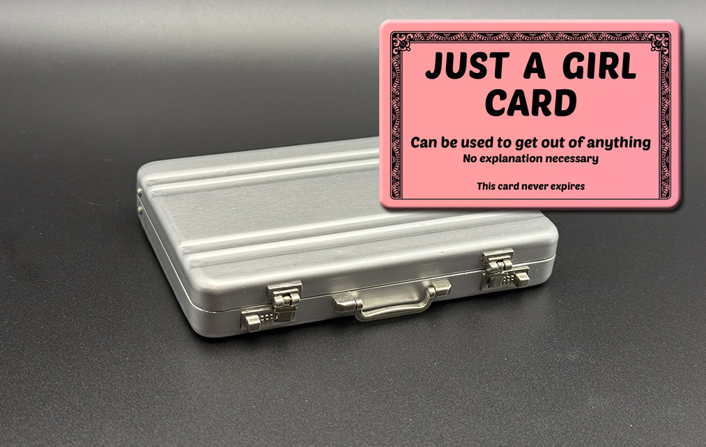 Silver mini briefcase with pink “JUST A GIRL” card holder on top