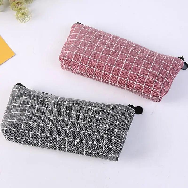 Two grid pencil cases: gray and pink, both with black zipper pull