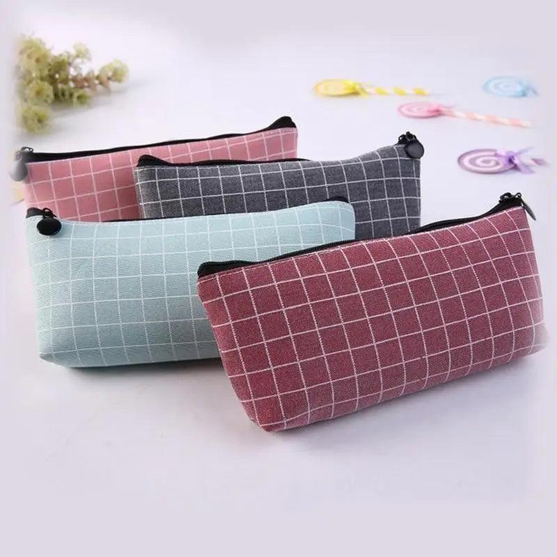 Grid-pattern pencil case set with zipper pulls; pink, light blue, and dark gray.