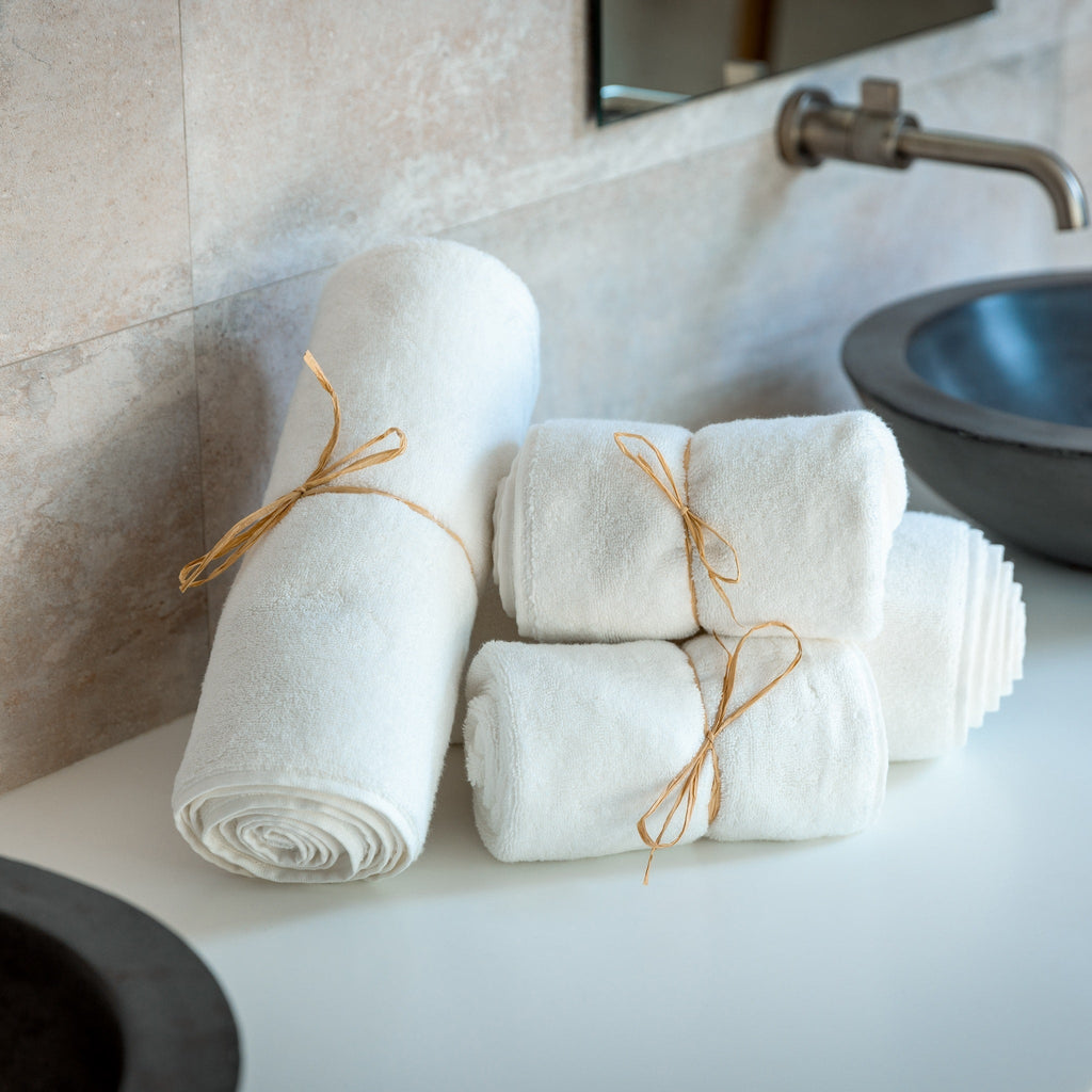 Rolled light blue bath towels tied with twine ribbon