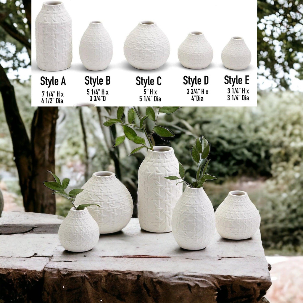 Five white web-pattern vases in mixed sizes, some with green stems