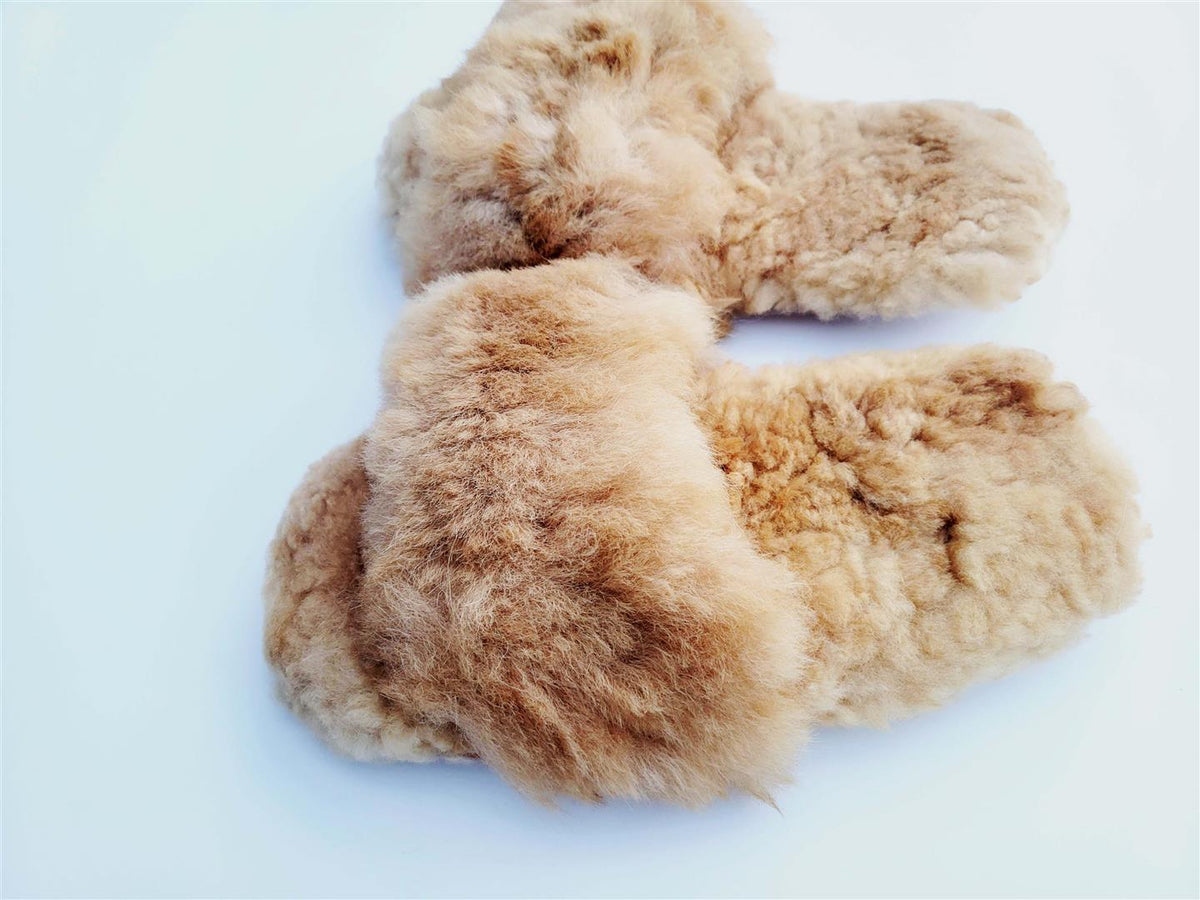 Pair of tan fuzzy alpaca-style fur slippers, laid flat side view