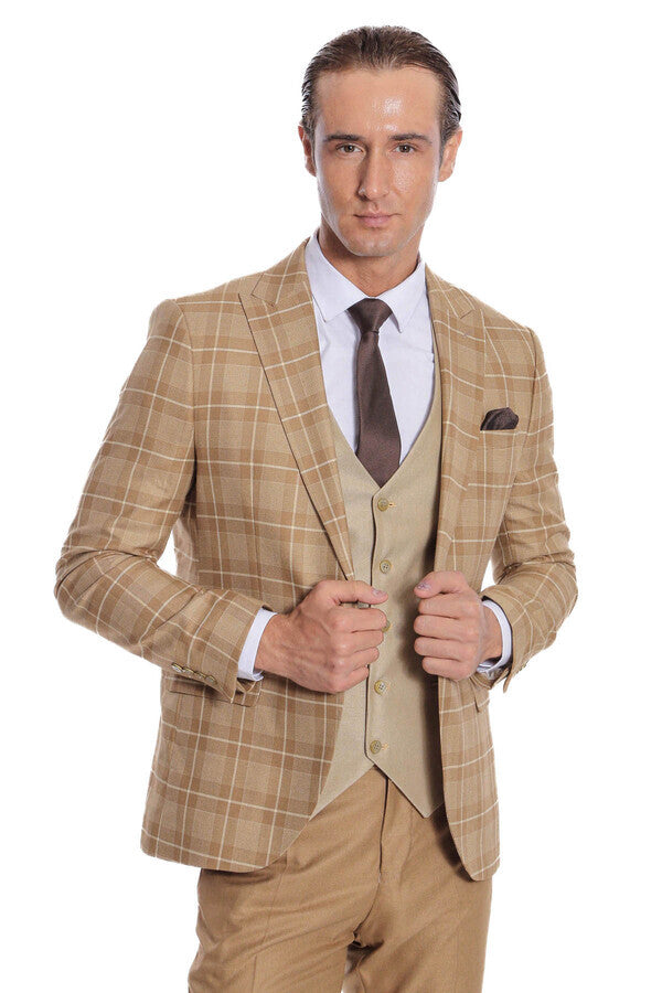 Men's checked tan blazer with beige waistcoat and dark tie, adjusting cuffs