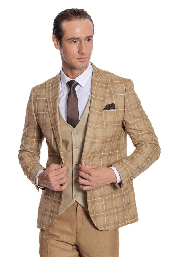 Men's checked tan blazer with beige waistcoat, dark tie, hands adjusting jacket