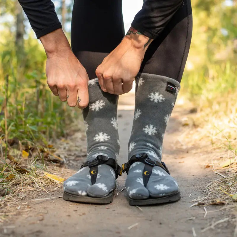 Dark gray snowflake fleece tabi socks worn with casual shoes on outdoor path
