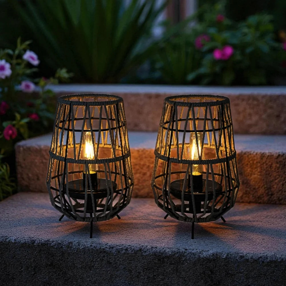 Set of 2 solar outdoor lanterns with black woven cages and warm lit glass bulbs