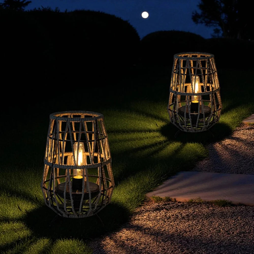 Set of 2 solar outdoor lanterns with black woven cages and warm light on path