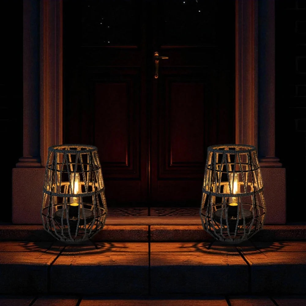 Set of 2 solar outdoor lanterns with black woven cages, warm-lit bulbs by door steps