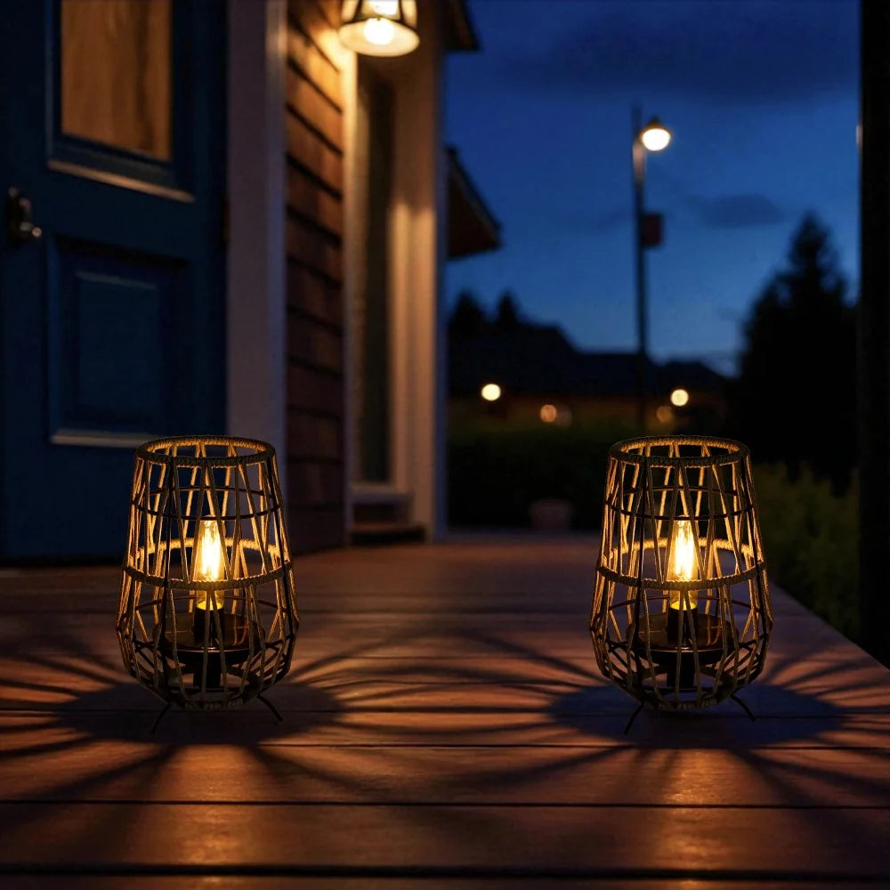 Set of 2 solar outdoor lanterns on porch with black woven cages and warm bulbs