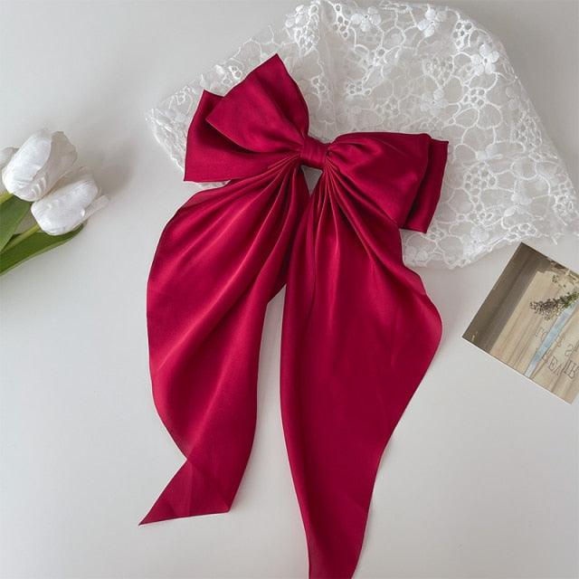 Deep red satin bow hair clip with long ribbon tails