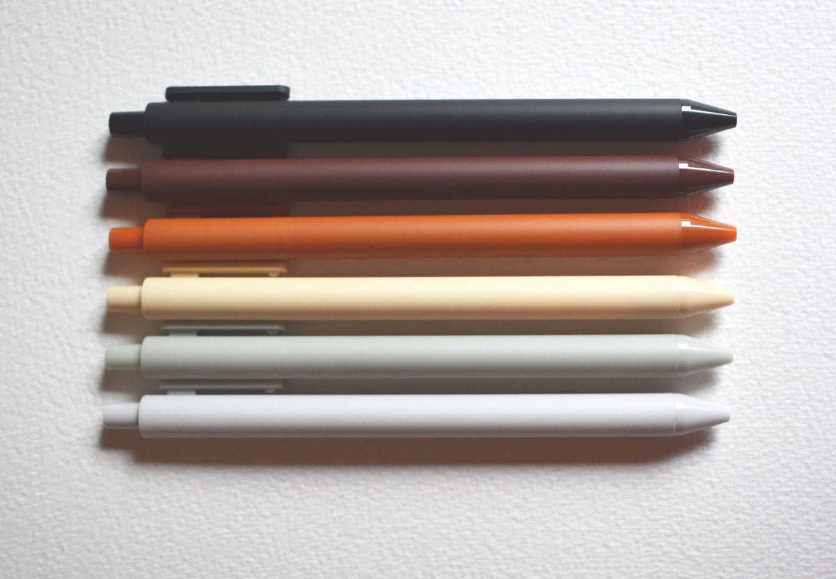 Warm gel pen set with capped pens in black, brown, orange, and cream