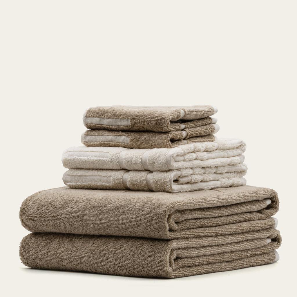 Stack of tan cotton towels with ecru stripes, neatly folded