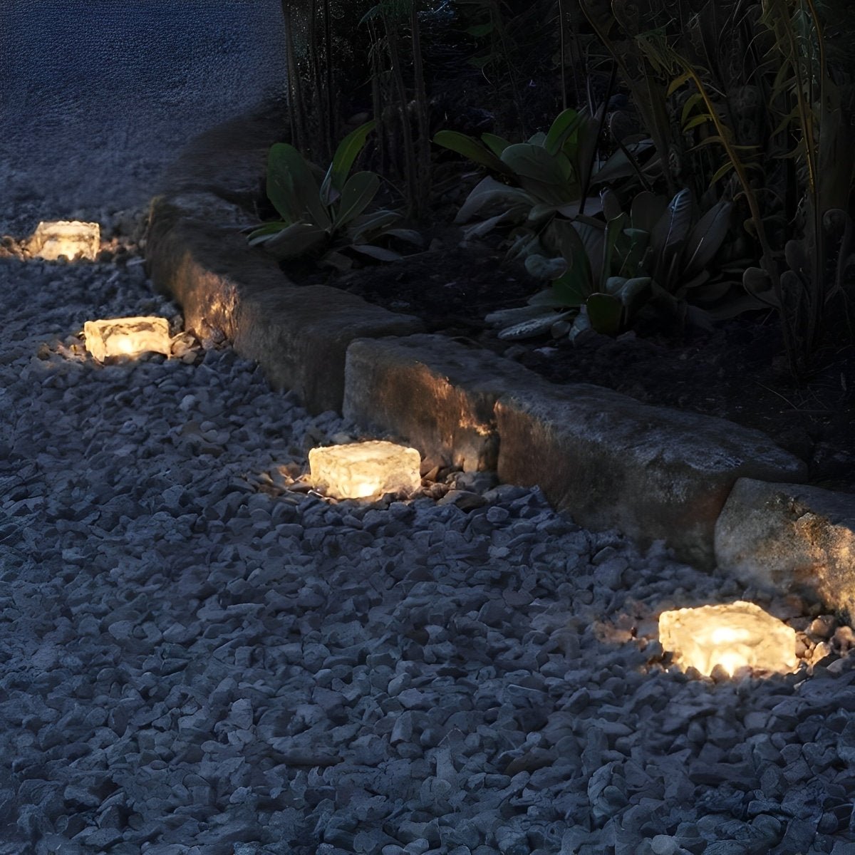 Solar LED ice brick path lights with warm yellow glow along a rocky walkway