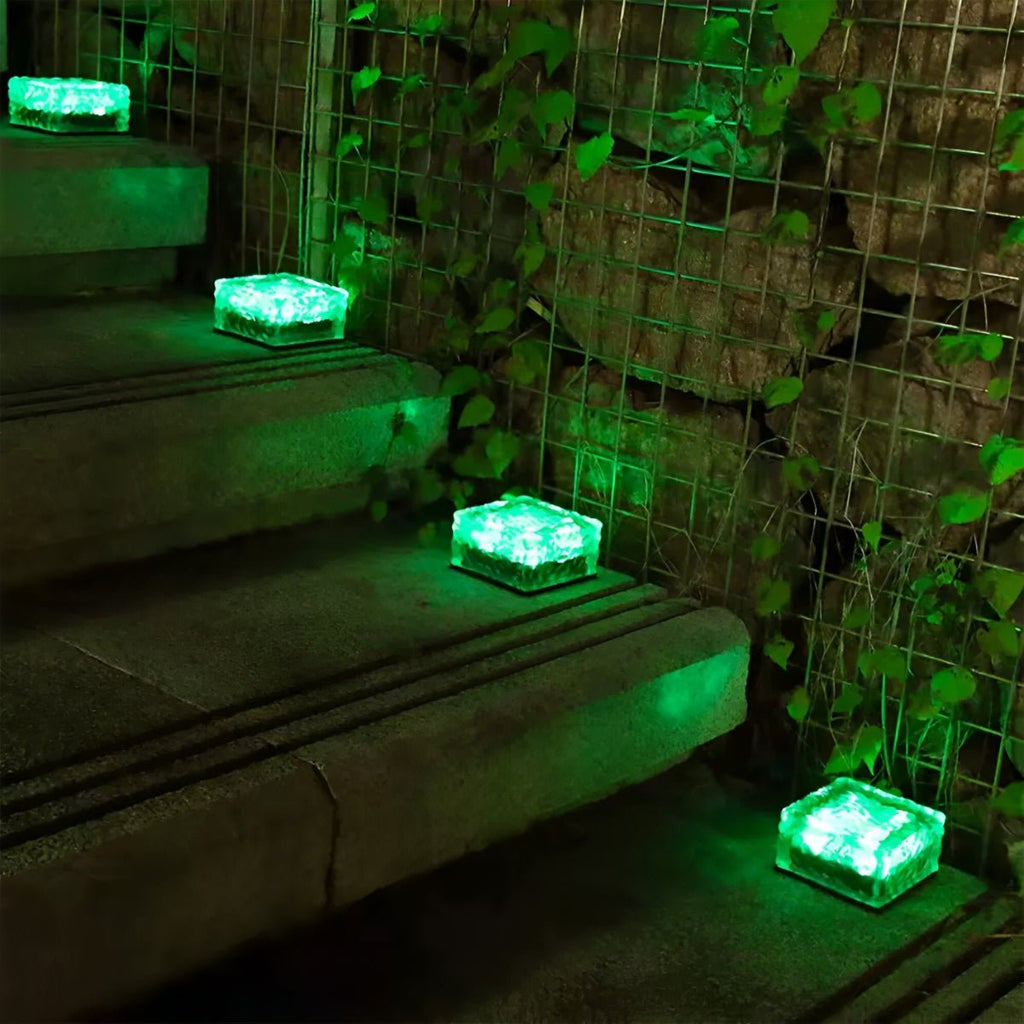 Solar LED ice brick path light with green glow, square top, outdoors on steps