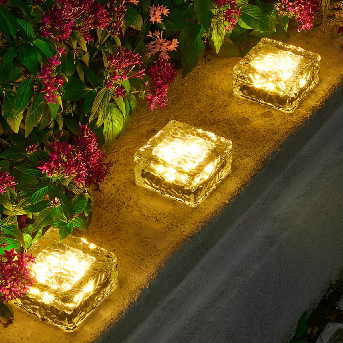 Solar LED ice brick path lights glowing golden yellow, square bricks on walkway