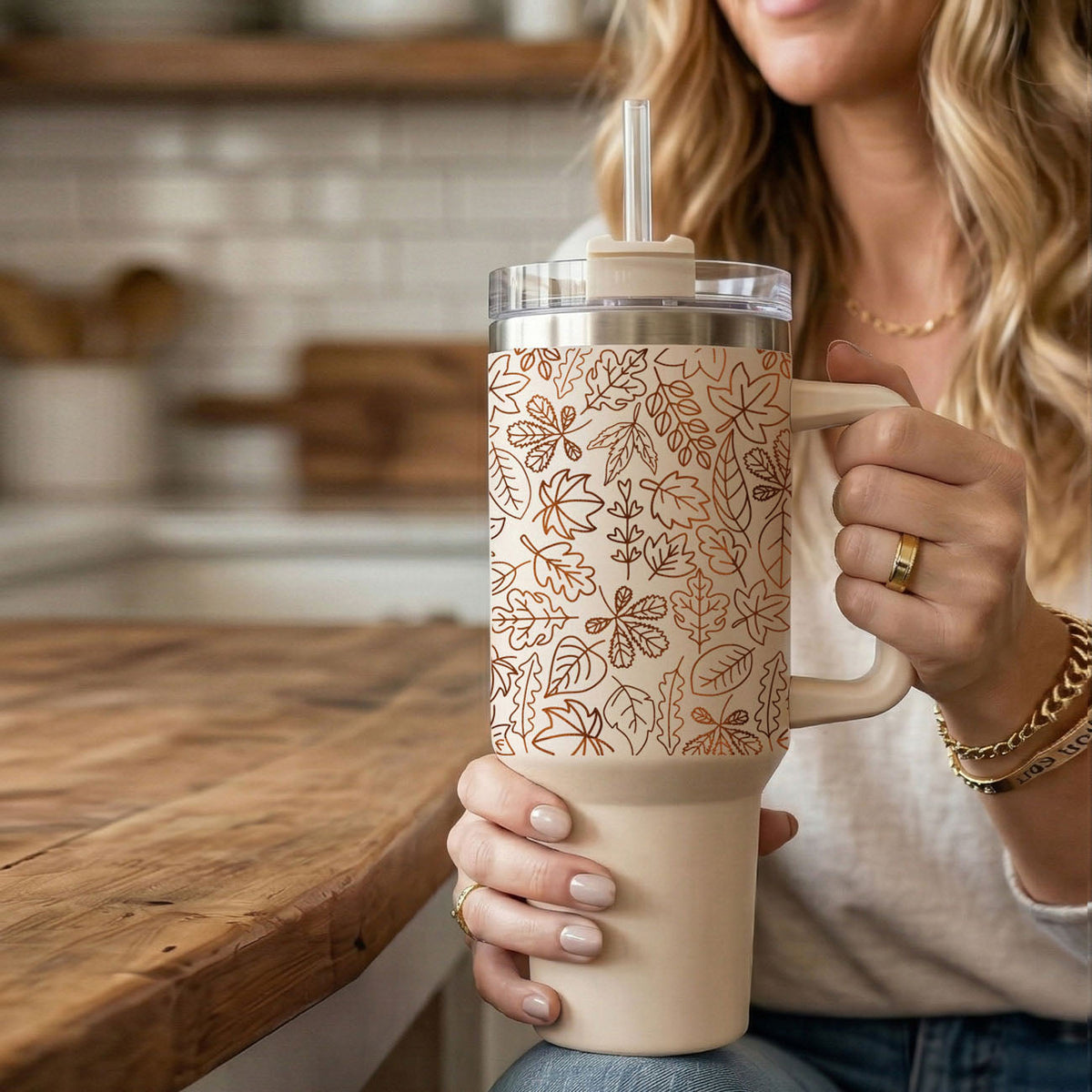 40oz cream tumbler with handle, clear lid, straw, and orange leaf line design.