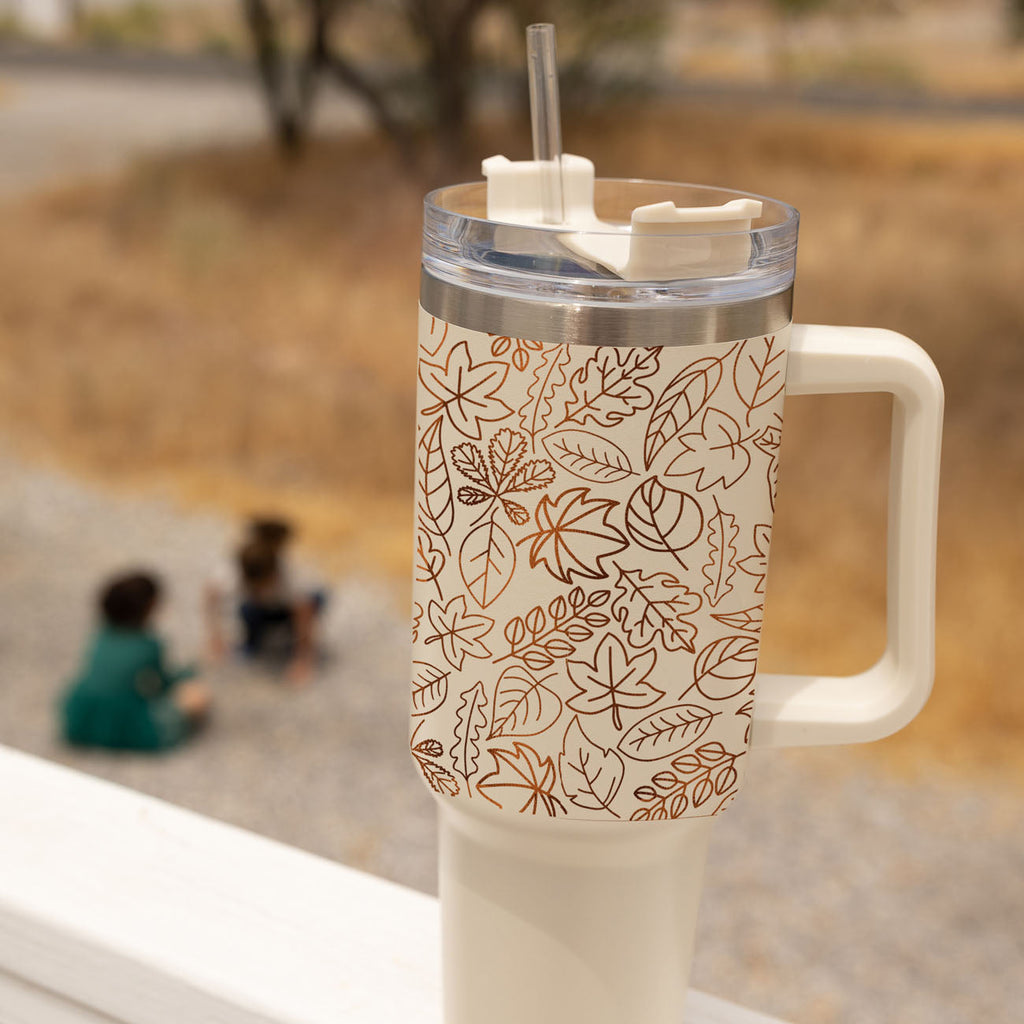 40oz cream tumbler with handle, clear lid, straw, and orange botanical line pattern.
