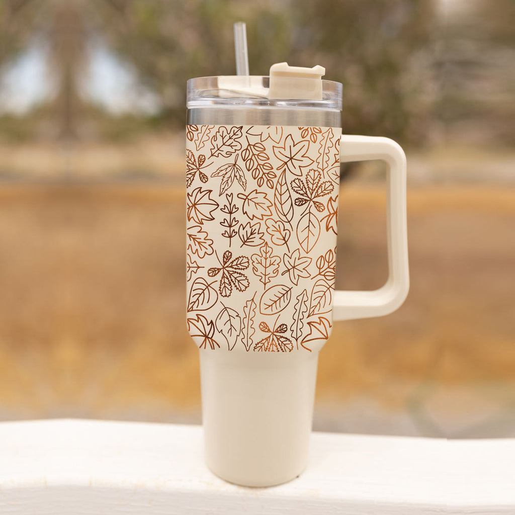 40oz cream tumbler with clear lid, straw, and orange leaf line pattern.