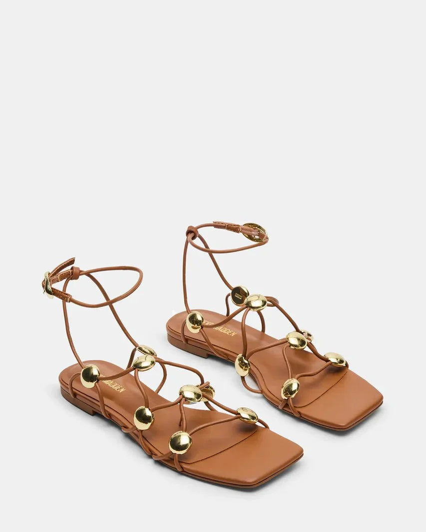 Cognac leather flat sandals with open toe, thin straps, and gold-tone round studs