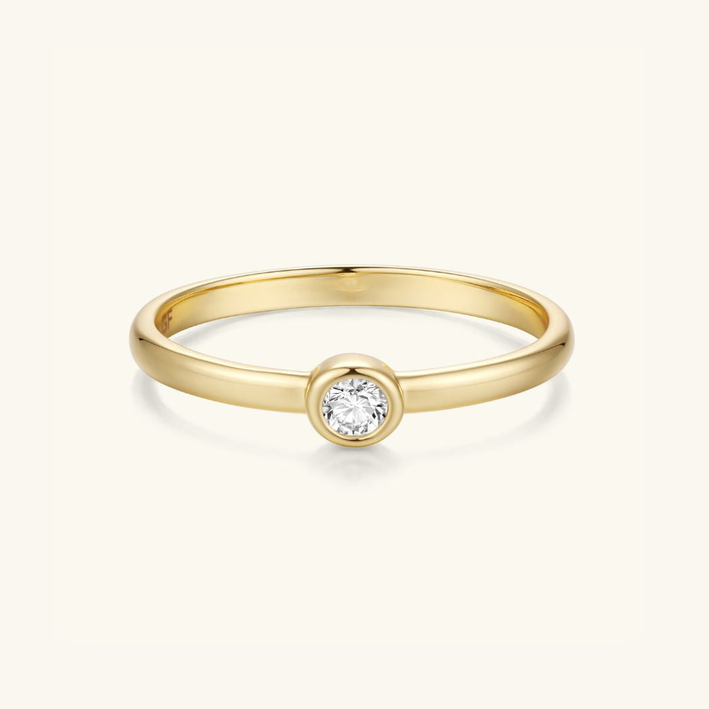 Gold-tone bezel-set round stone ring with slim band