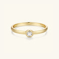 Gold-tone bezel-set round stone ring with slim band