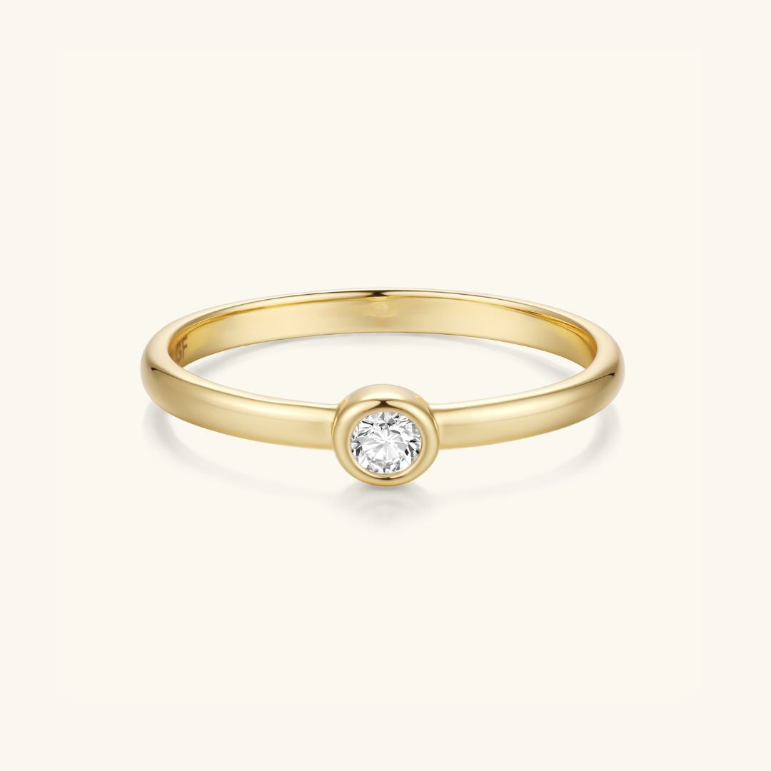 Gold-tone bezel-set round stone ring with slim band