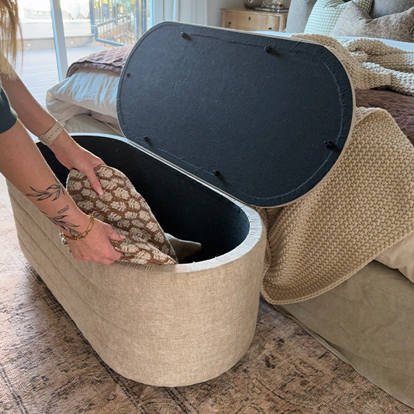 Upholstered nesting storage bench with open round lid showing dark interior compartment