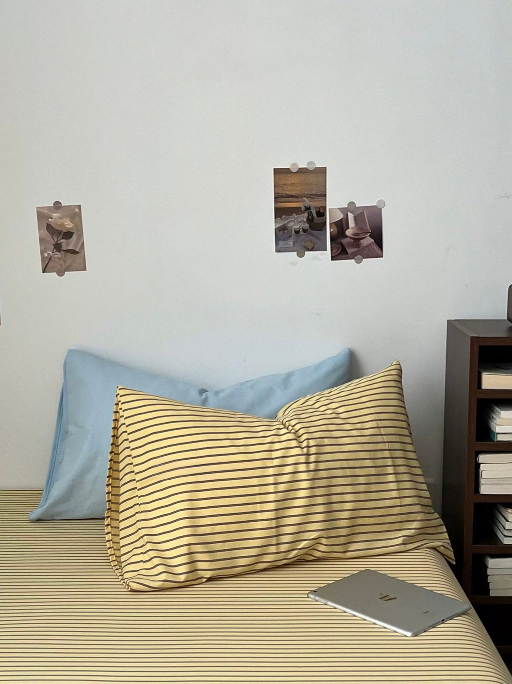 Yellow striped pillow shams and blue pillow with dark brown bedding set on bed