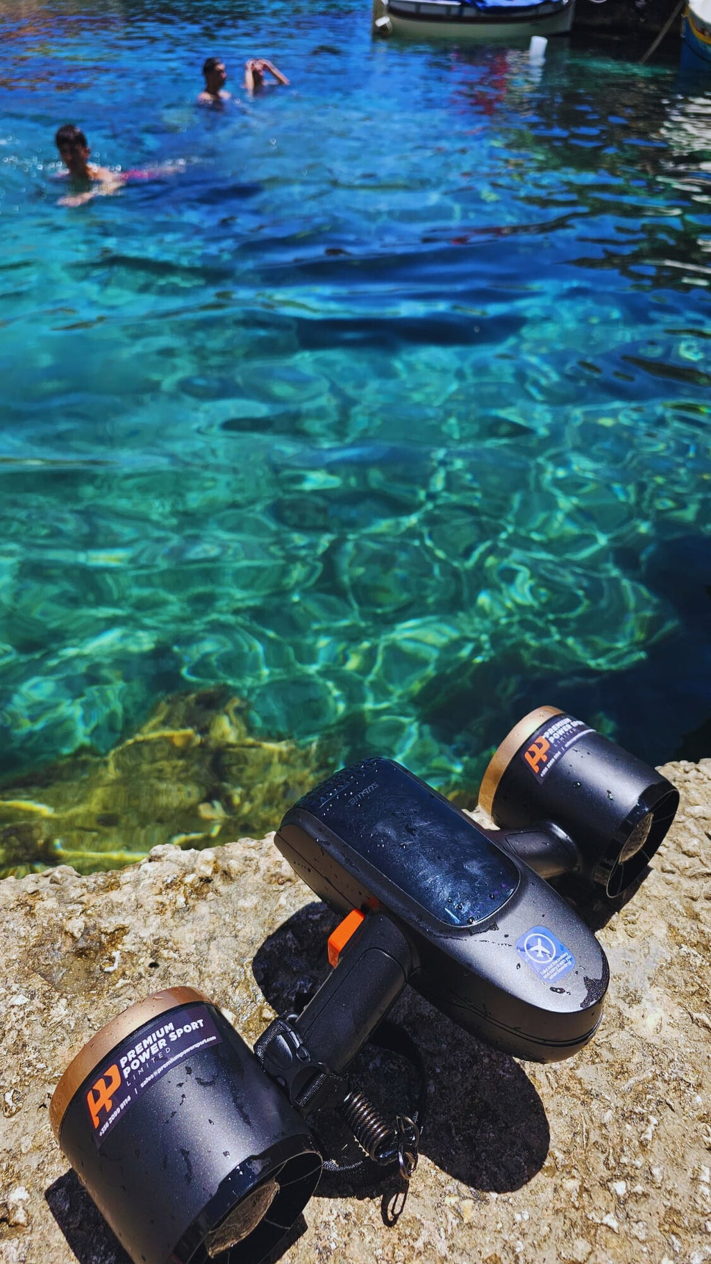 Underwater drone on pool floor with dual side fans and blue carry strap