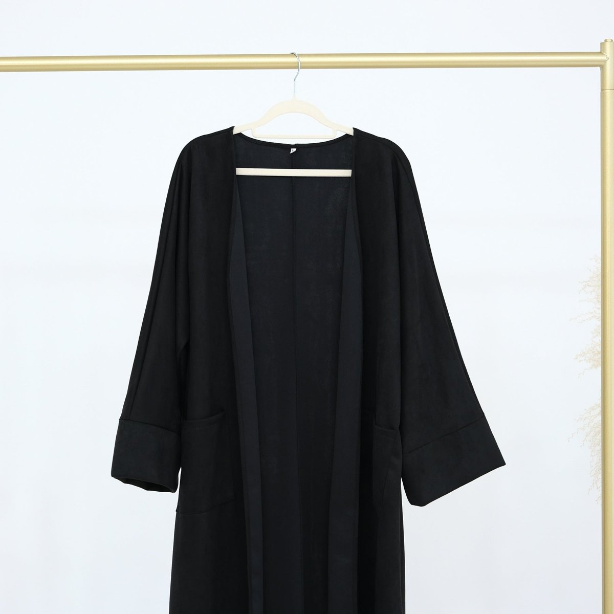 Black suede open-front long abaya cardigan with 3/4 sleeves on hanger