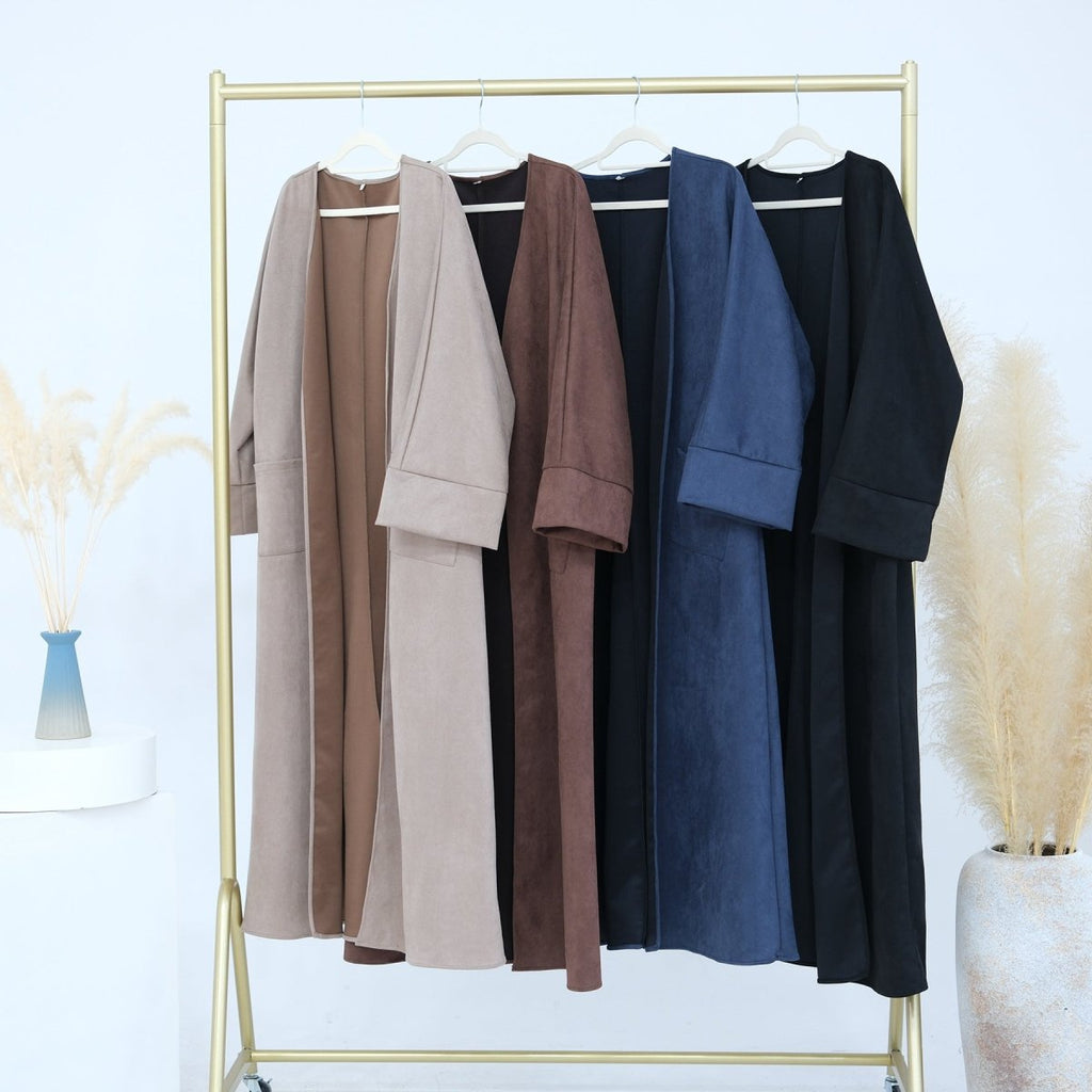 Suede open-front abaya cardigans in multiple colors, long sleeve, on display rack