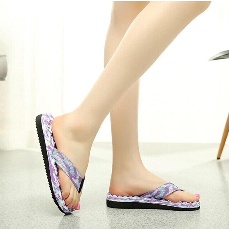 Purple camo thong flip-flops on feet with cushioned platform sole