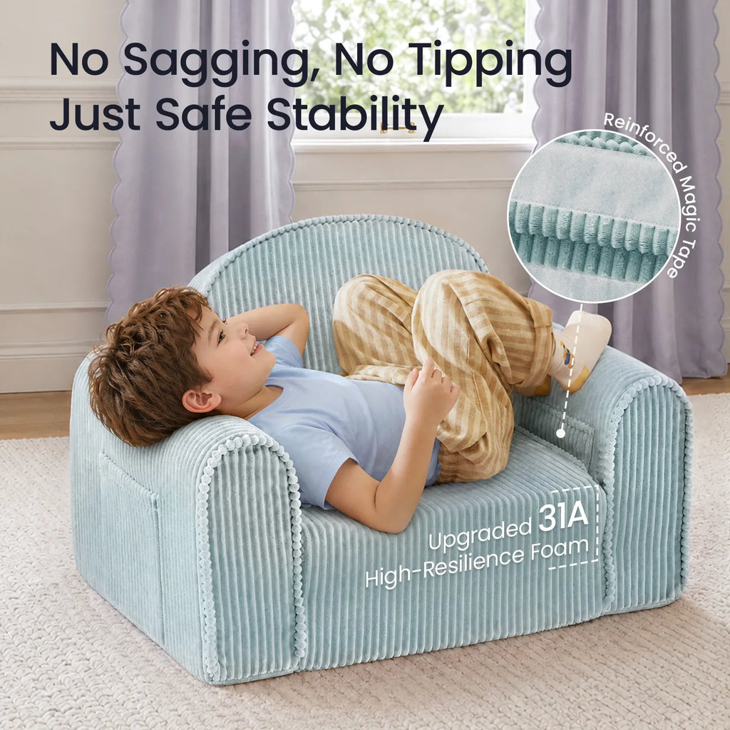 Teal corduroy kids sofa with kid lying across the seat, rounded back and padded arms