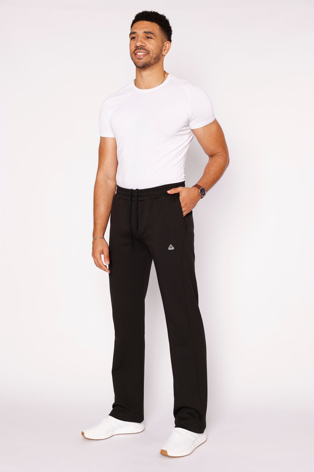 Black straight-fit sweatpants with drawstring waist, side pockets, and small logo patch on leg.