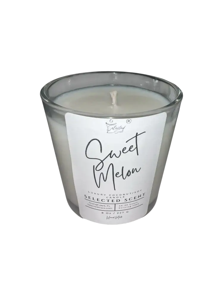Sweet melon scented candle in clear glass jar with white wax and visible flame