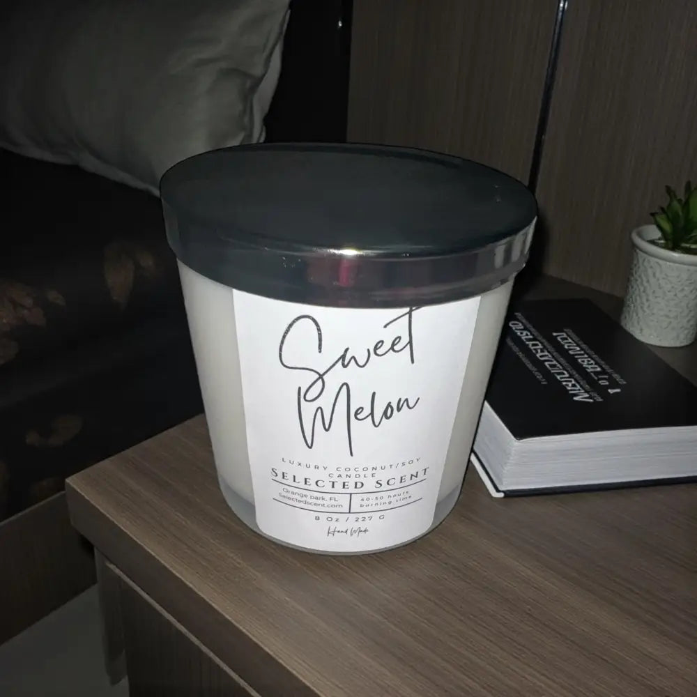 Sweet melon jar candle in clear glass with black lid and printed label