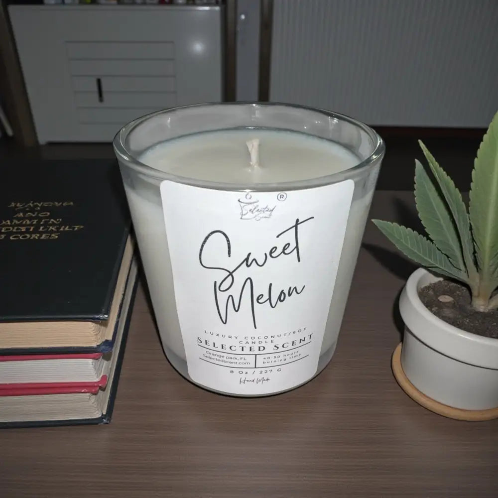 Sweet melon candle in clear glass jar with white wax and lit wick