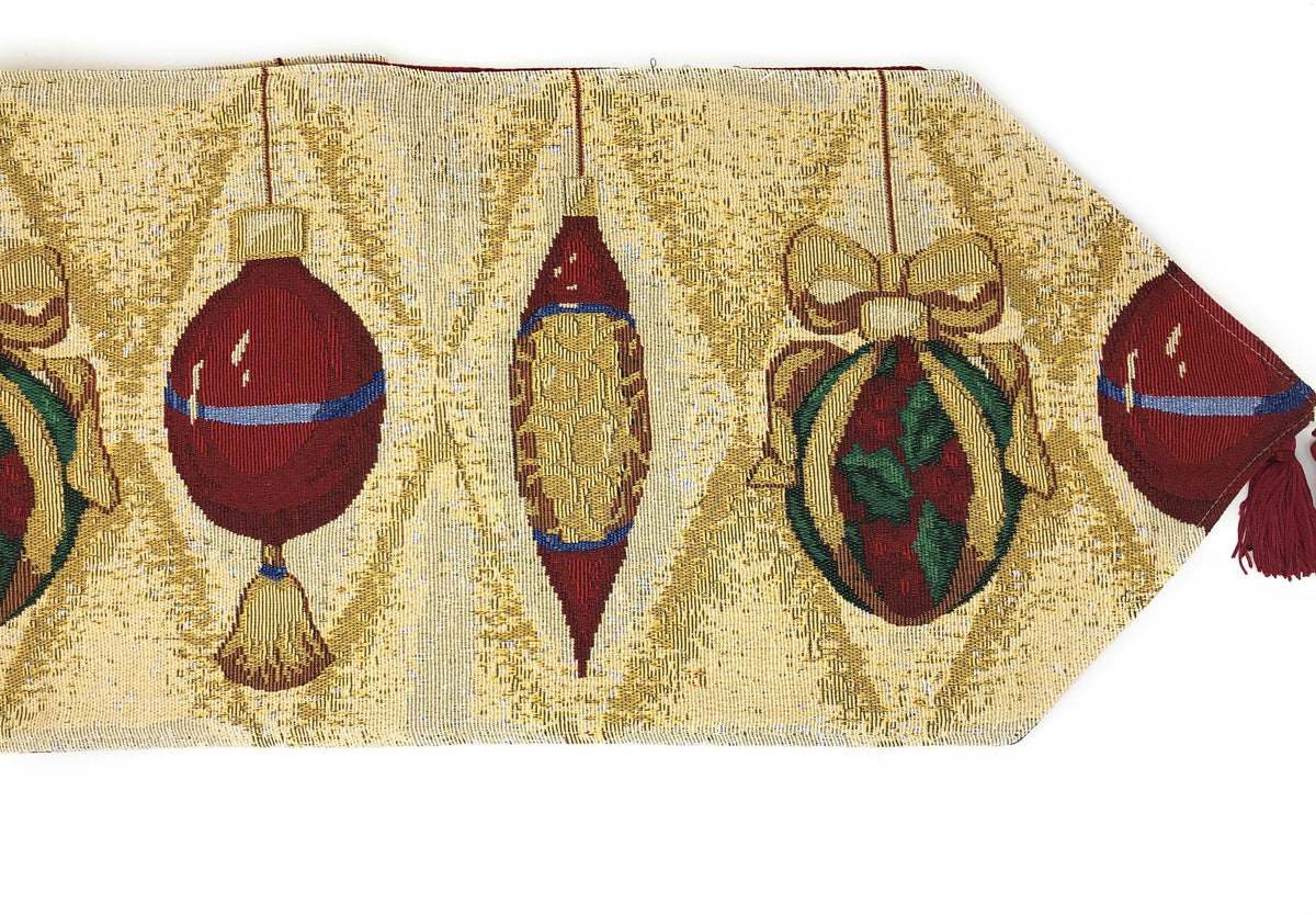 Gold tapestry table runner showing red ornament baubles and green candles, with red fringe