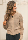 Three-quarter view of beige open-knit zip cardigan with long sleeves and ribbed trim.
