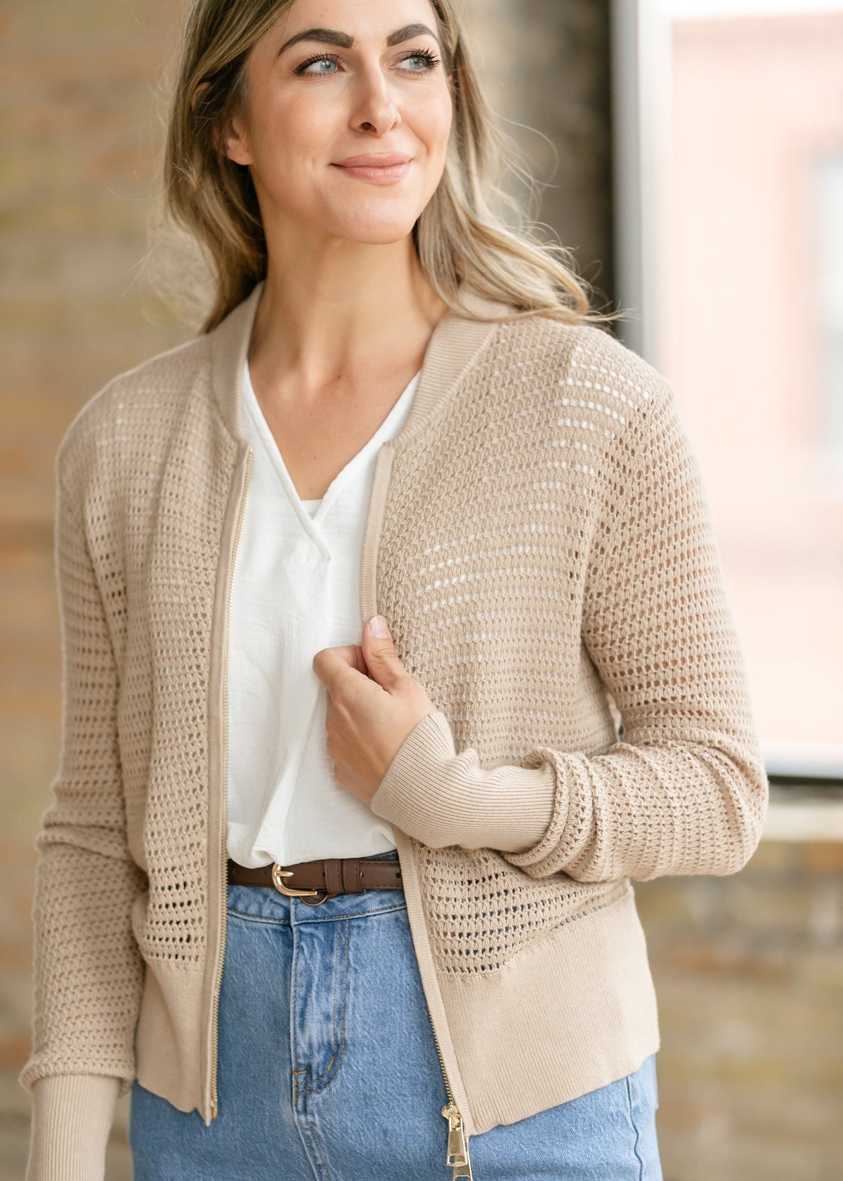 Beige open-knit crochet cardigan with zip-front and long sleeves over a white blouse