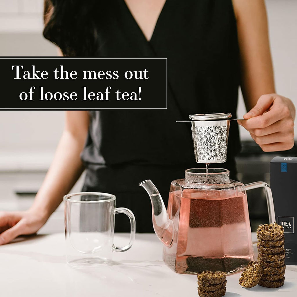 Loose-leaf tea disc steeping in a glass teapot with a metal infuser