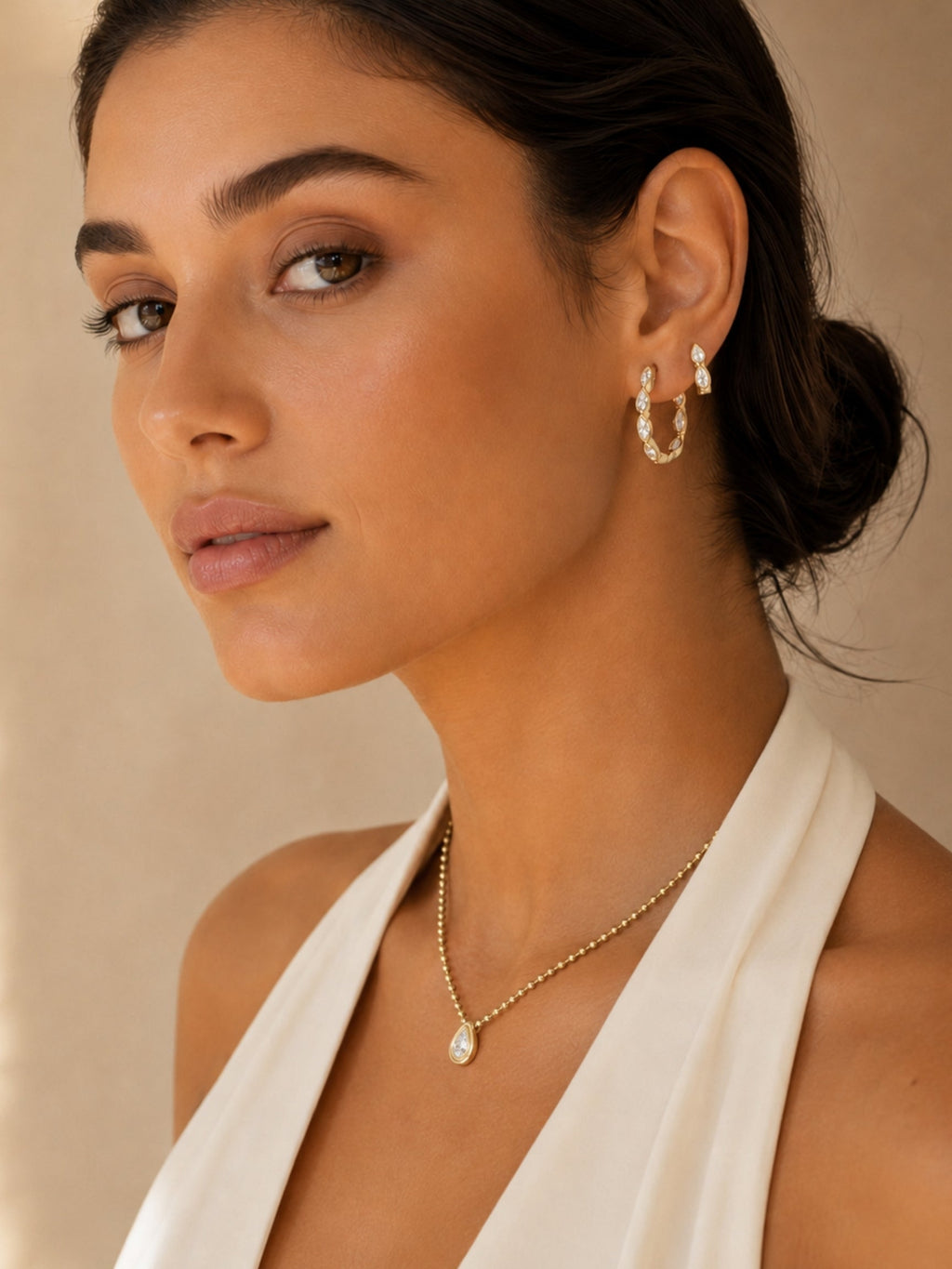 Gold teardrop diamond necklace with beaded chain and teardrop pendant on the collarbone