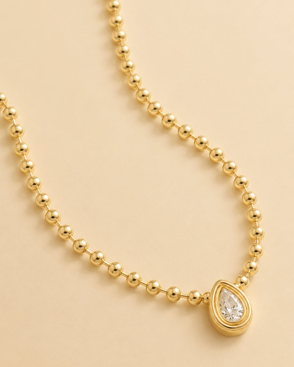 Gold beaded chain teardrop diamond pendant with round halo centerpiece