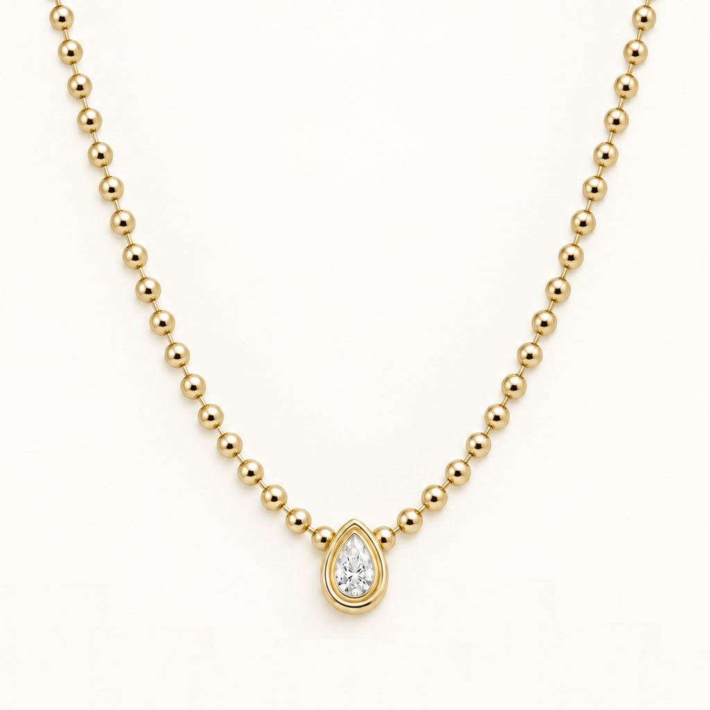 Gold beaded necklace with a teardrop diamond pendant in a round halo setting