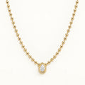 Gold beaded necklace with a teardrop diamond pendant in a round halo setting