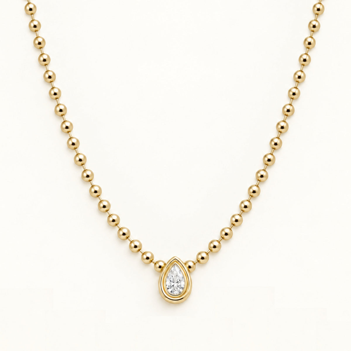 Gold beaded necklace with a teardrop diamond pendant in a round halo setting